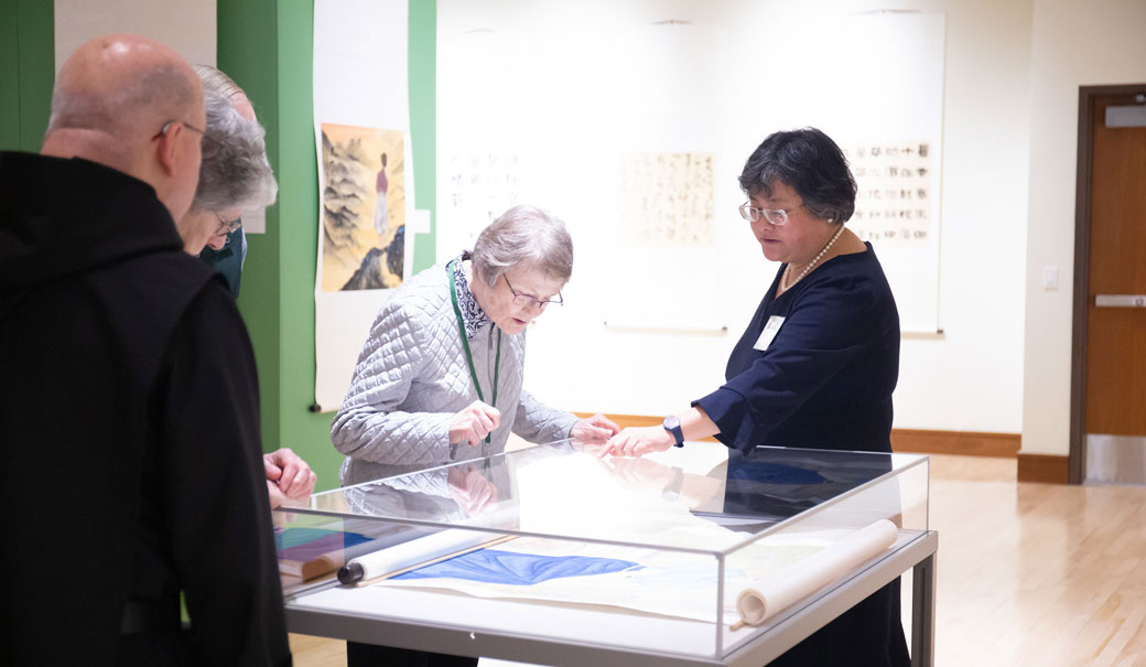 Visitors examining historical documents in a museum setting.
