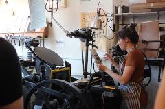 Haylee Ebersole demonstrates antique printing equipment.