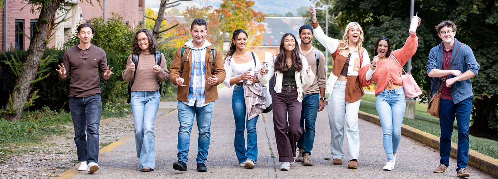 A diverse group of students walking together on campus, smiling and enjoying their time outdoors.