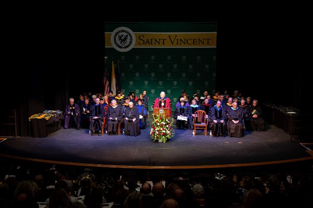 PHOTO: Father Paul R. Taylor, O.S.B., addresses graduates at the 2019 December Commencement in the Robert S. Carey Student Center Performing Arts Center