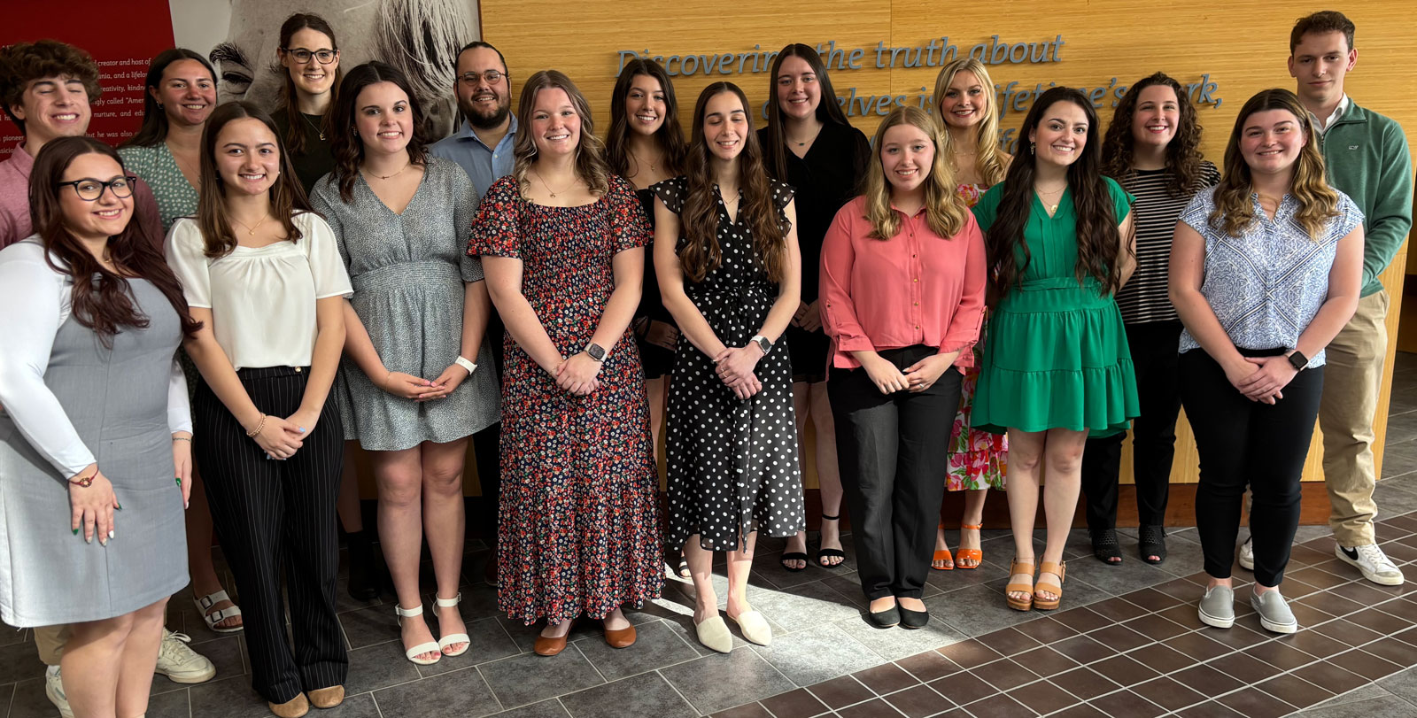 Group photo of students and faculty members posing together in a professional setting.